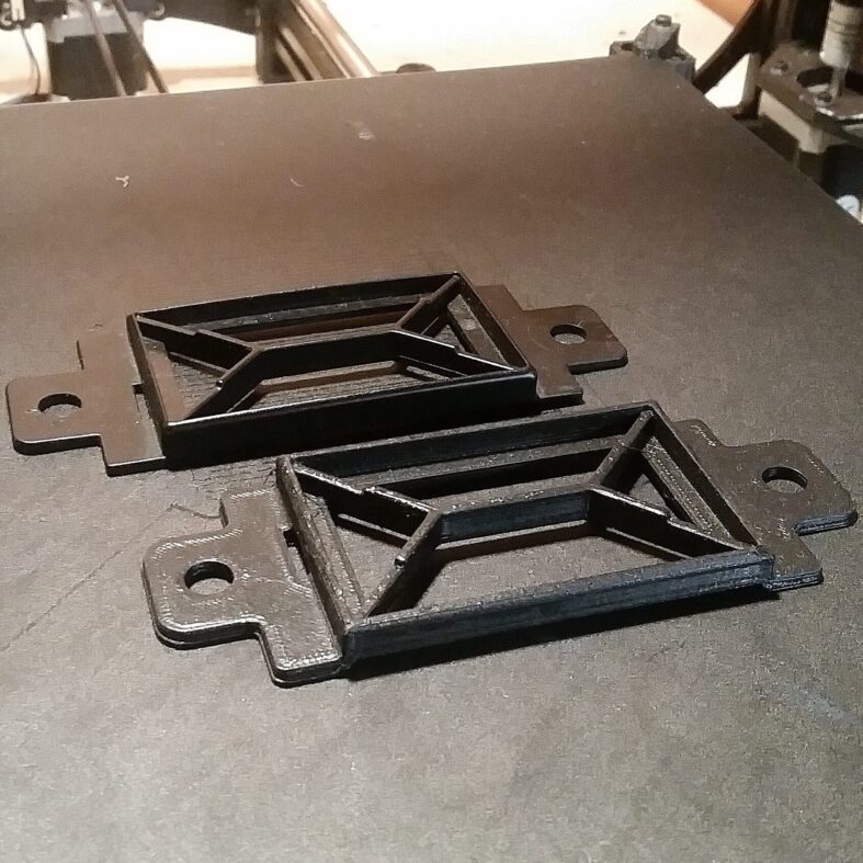 Two black 3D printed prototype components